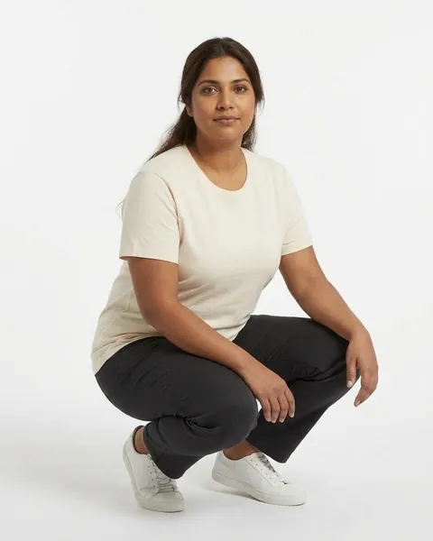 Fictional AI model Leila — crouching view in a neutral studio