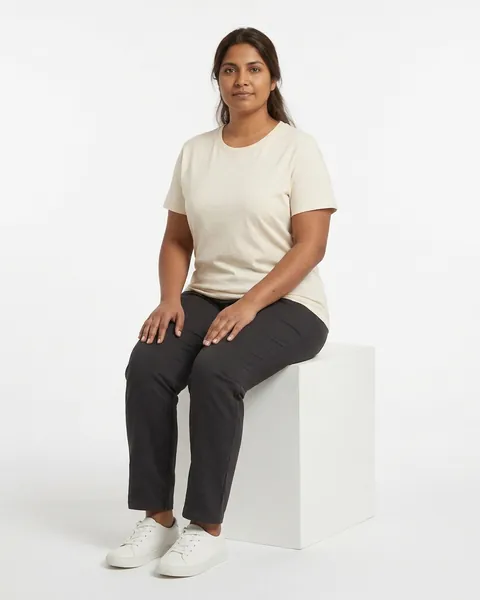 Fictional AI model Leila — seated view in a neutral studio