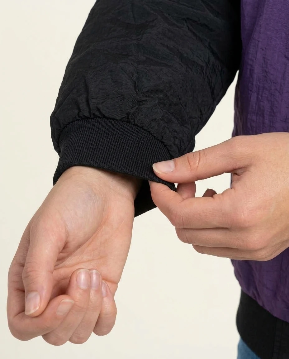 AI-generated purple varsity jacket photography: cuff interaction